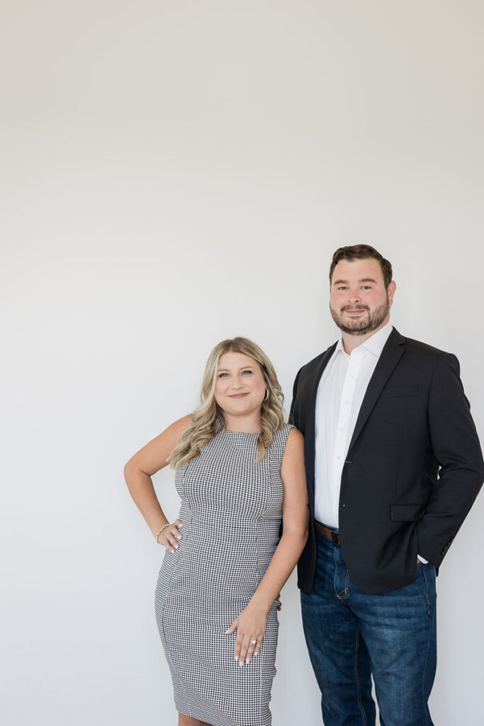 Local realtors posing for a professional portrait inside a modern home.
