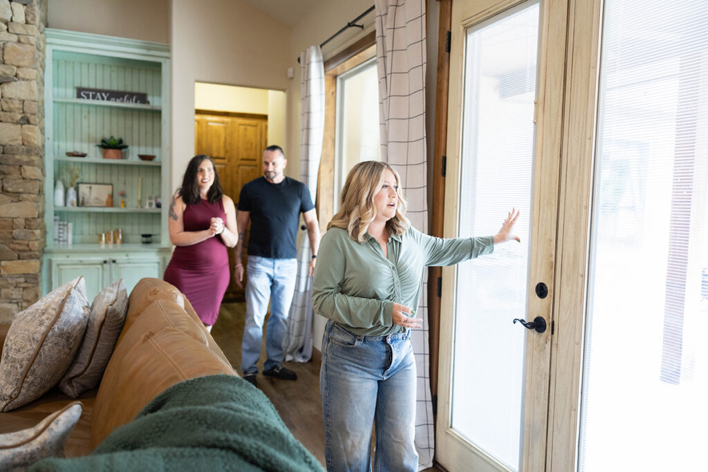 Real estate agent explaining home features during the steps to buying a house while touring a property with buyers.
